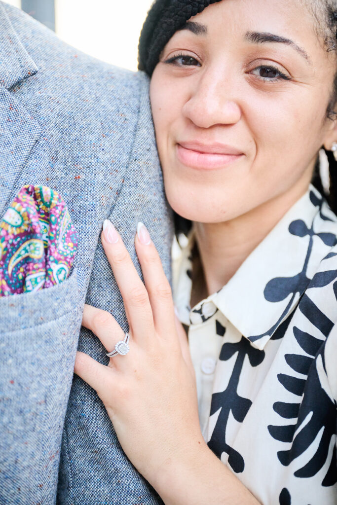 Close up picture, showing the engagement ring and Lady resting on Gentleman's shoulder.  Proposal in New York City, by Corey Lamar Photography at Pier 17 Rooftop