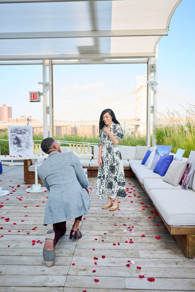 Proposal Happening, Elliott on bended knee, proposing to Janae at the Greens, Pier 17 Rooftop.