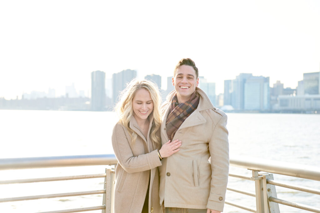 Couple Stands together happily smiling after a successful proposal in Gantry Plaza Park, in Long Island City Queens New York - Corey Lamar Photography