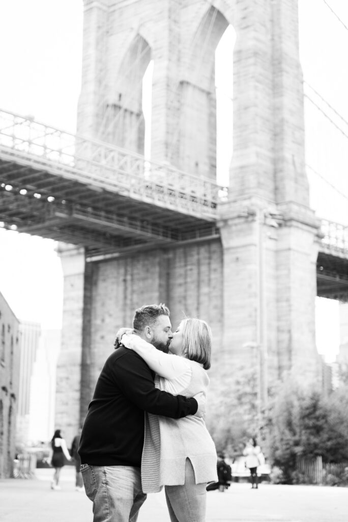 Black & White Photo of a couple right after a successful proposal in Brooklyn Bridge Park - Captured by Corey Lamar Photography