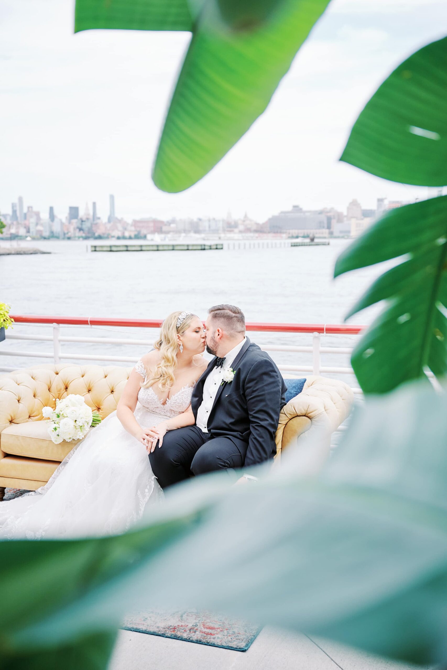 Bride and Groom share a kiss on the patio of the Battello Wedding Venue with the Hudson River in view overlooking the NYC skyline