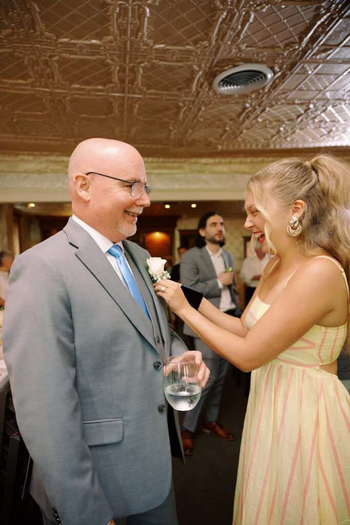 Daughter fixes Grooms Boutonniere after Ceremony Concludes in the Hudson House. 