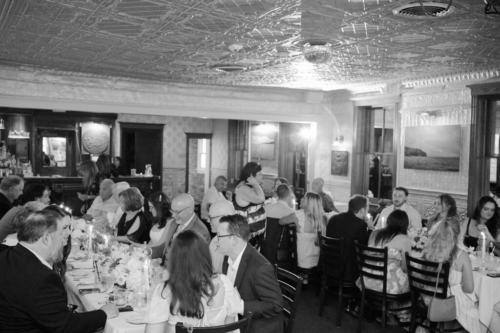 Friends and Family Sit together dinner table style after an intimate Ceremony in the Hudson House Restaurant Venue in Hudson Valley