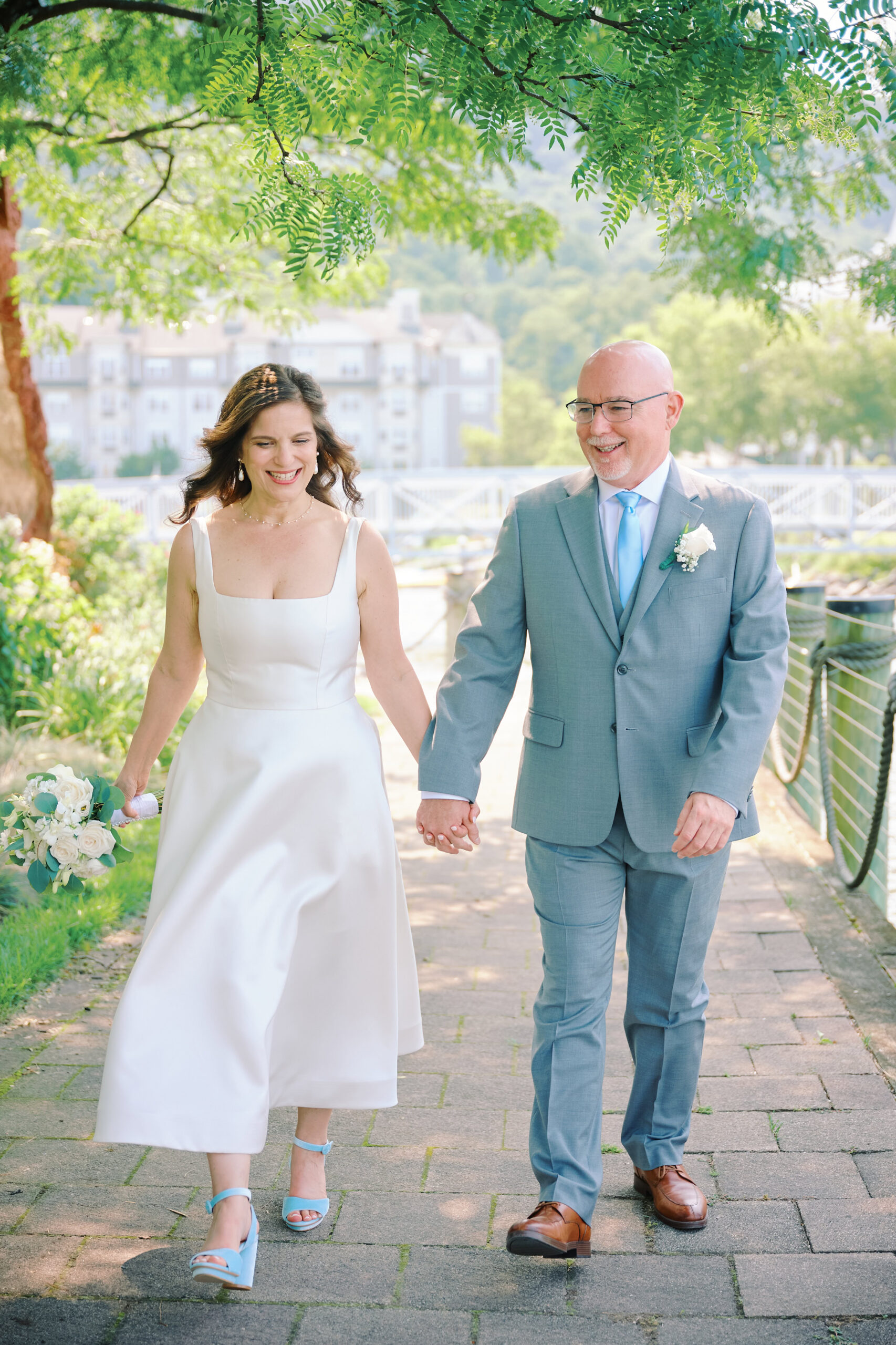 Bride and Groom Walk hand in hand in the Hudson Valley for their wedding, in a small village in the Hudson Valley New York