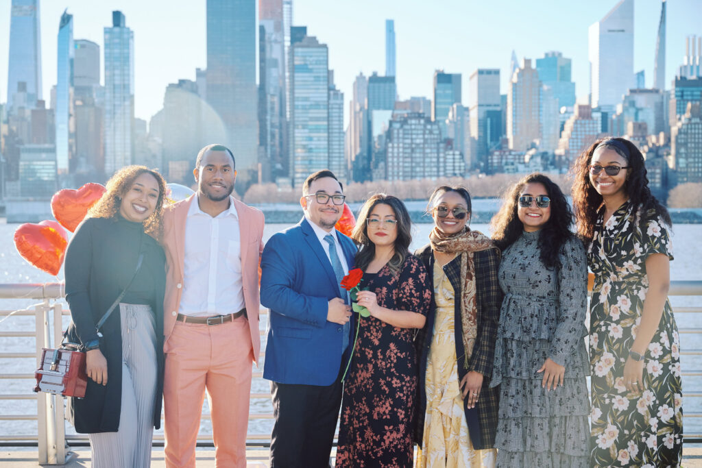 Friends Gather together in front of the New York City Skyline, after a successful Proposal