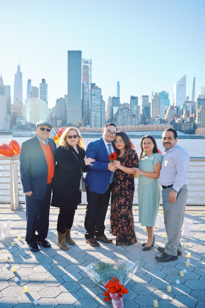 Family Gather together in front of the New York City Skyline, after a successful Proposal