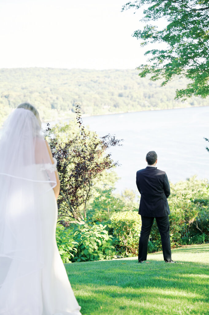 Groom overlooks the Connecticut River at the Saint Clements Castle and Marina, awaiting first look with his bride