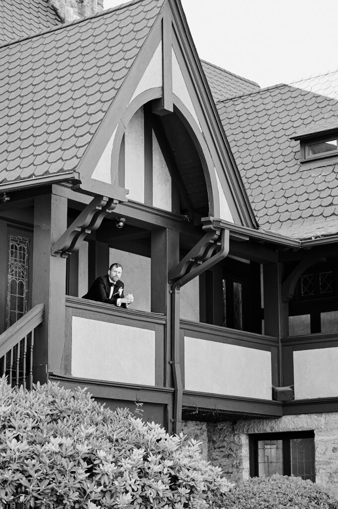 Groom overlooking balcony at the Saint Clements Castle. Photo is in black and white for artistic effect, taken by Corey Lamar Photography, New York City Wedding Photographer