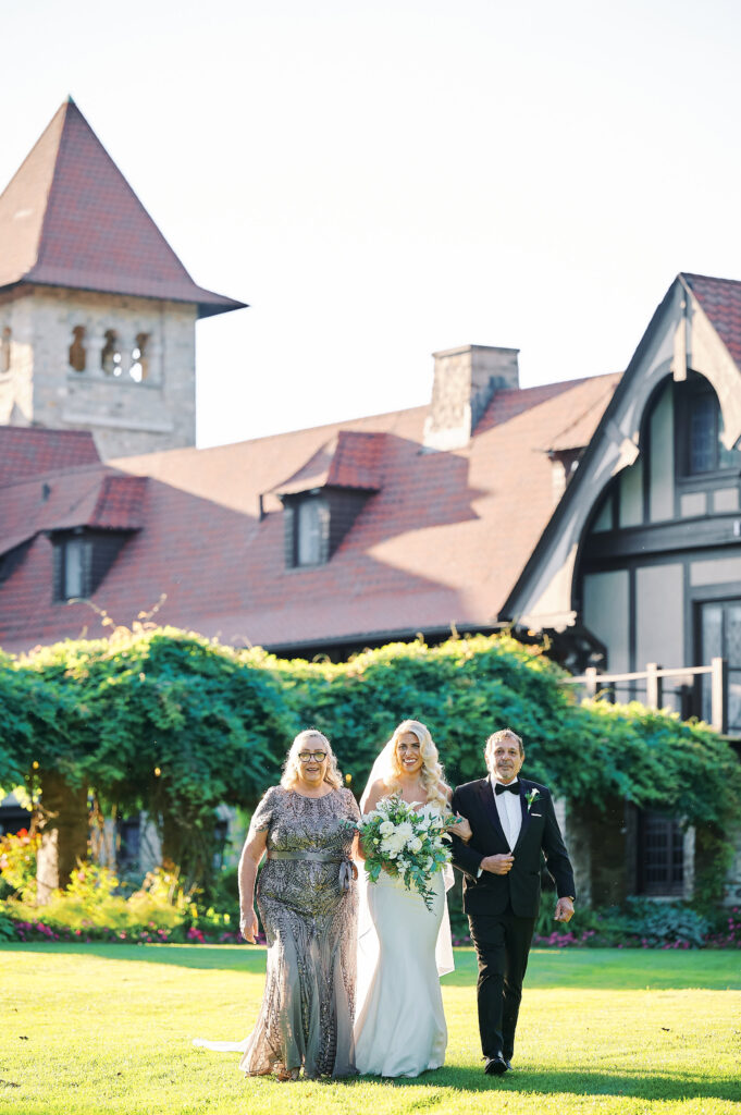 Bride along with her parents walk to Ceremony location in the Saint Clements Castle Gardens.  Photo taken by NYC Wedding Photographer Corey Lamar Photography