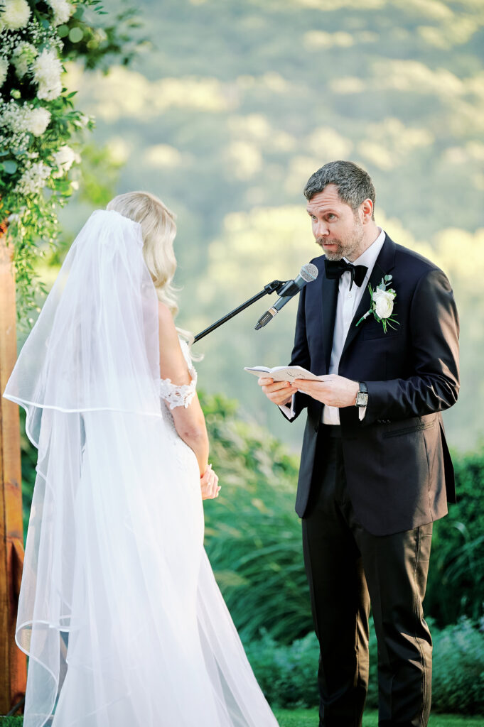 Groom Reads his vows to his bride during their outdoor ceremony at the Saint Clements Castle