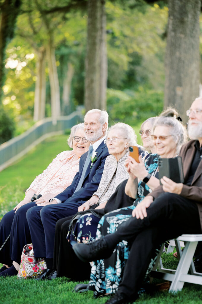 Grandparents look on wedding ceremony happily. Outdoor Ceremony at Saint Clements Castle in Portland Connecticut