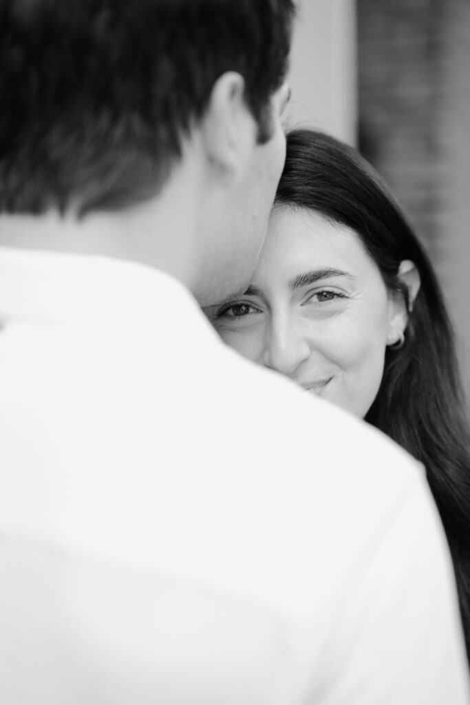 Black-and-white portrait of Vanessa peeking over Mark’s shoulder in a West Village engagement photo