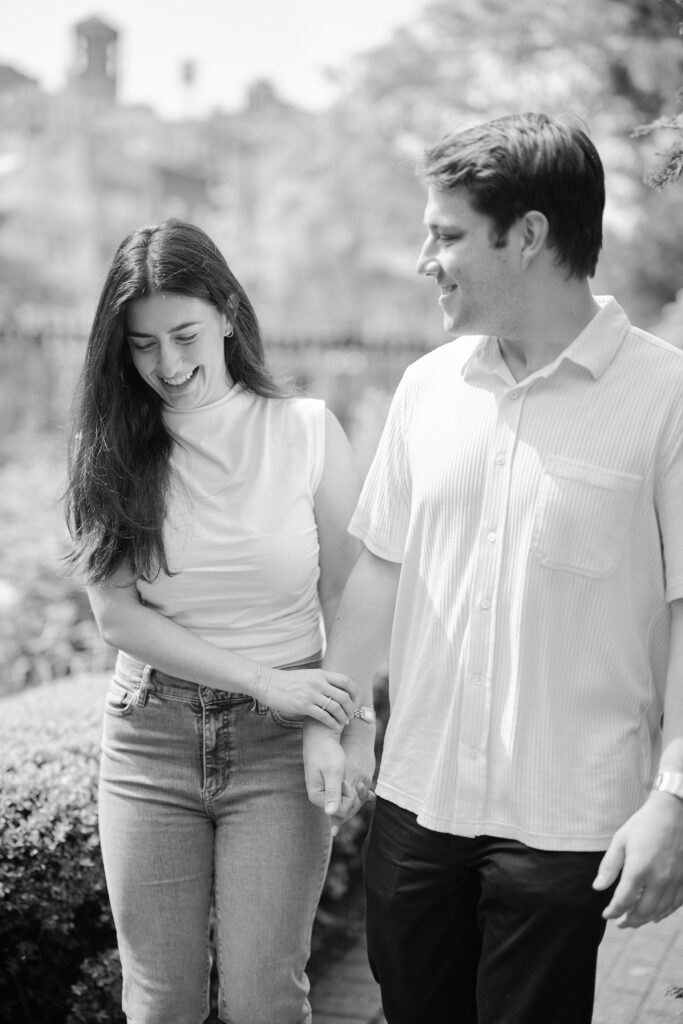 Black-and-white West Village engagement photo of Vanessa and Mark walking down secret garden path