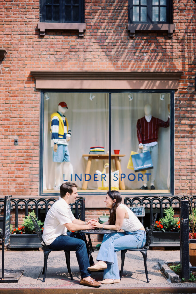 Mark and Vanessa seated at an outdoor West Village café table during their engagement session
