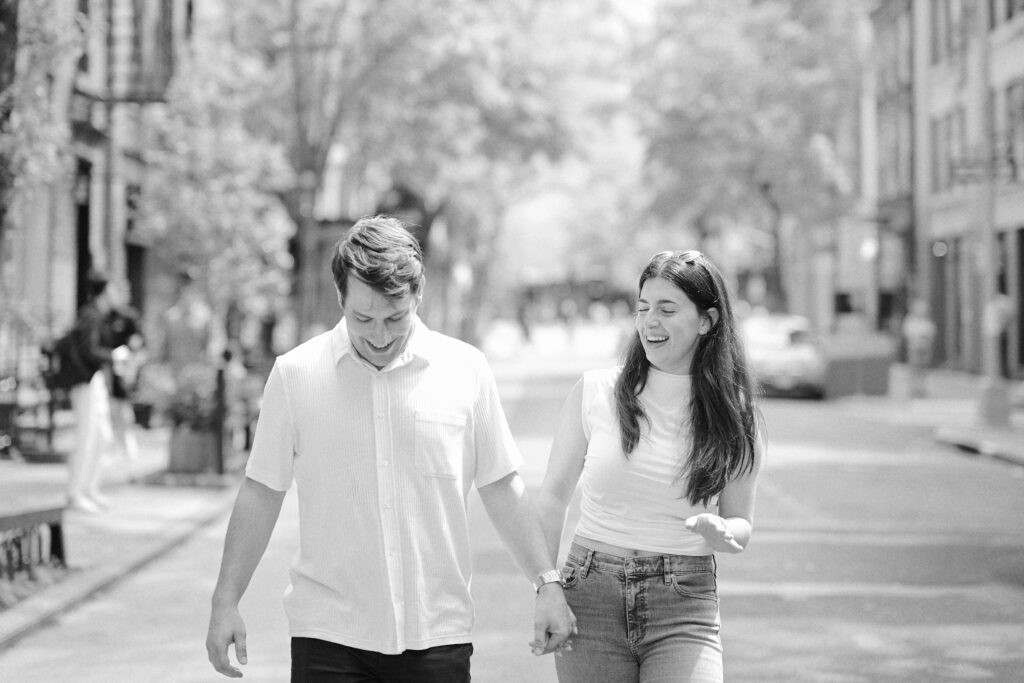 Black and White image of Mark and Vanessa walking hand in hand down a West Village street during their engagement photos session